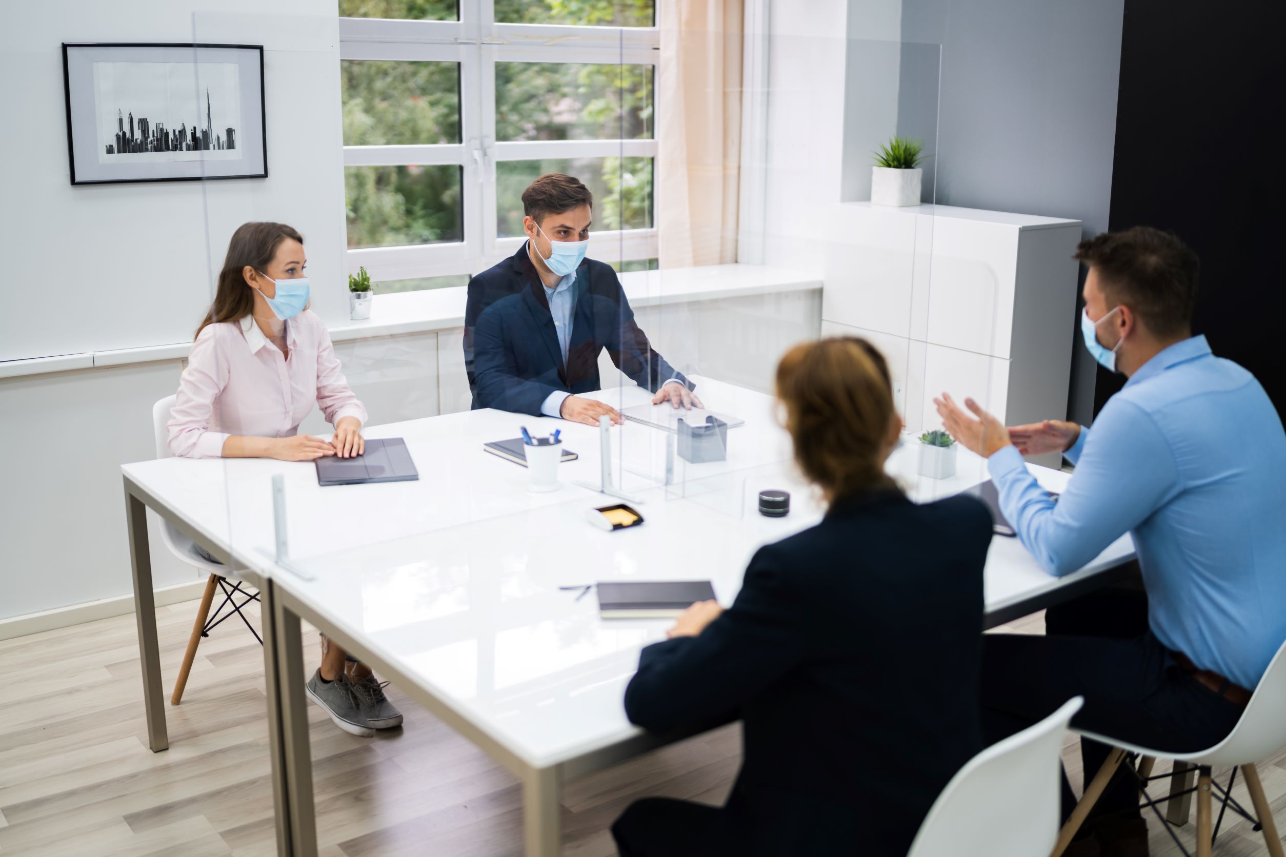 A group of people in the office in a COVID friendly environment.